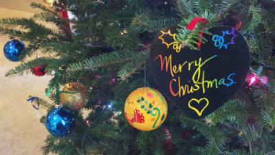 A 'Merry Christmas' sign is seen here on a Christmas tree.