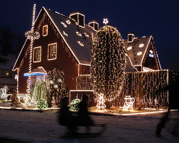 Children play with their sled in front of the house of Lutz Pingel in Germany, which is decorated with Christmas lights, in Dortmund November 30, 2010. Each year several owners set up fairy lights at their houses for Christmas.