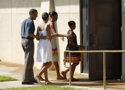 U.S. President Barack Obama walks with first lady Michelle Obama (2nd R), and their daughters Malia (2nd L) and Sasha into a Christmas morning church service at Marine Corps Base Kaneohe Bay in Hawaii, December 25, 2011.