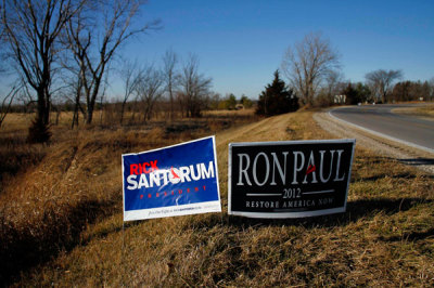 Campaign signs for U.S. Republican presidential candidate and former Pennsylvania Senator Rick Santorum and U.S. Republican presidential candidate and Representative Ron Paul are seen along a road in Dallas County, Iowa December 24, 2011.