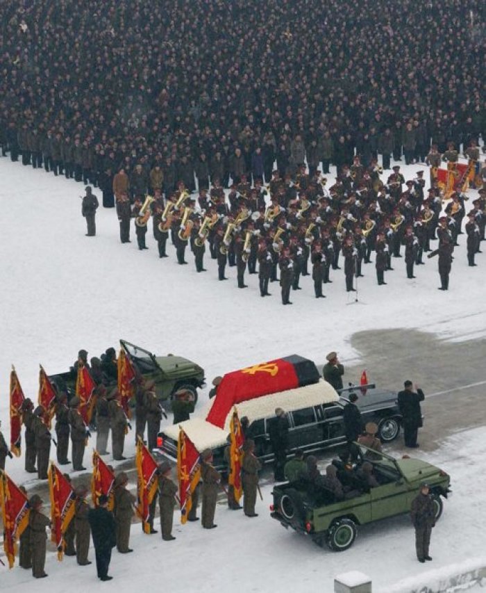 North Korea's new leader Kim Jong-un (R) salutes as he and his uncle Jang Song-thaek (standing behind Kim) accompany the hearse carrying the coffin of late North Korean leader Kim Jong-il during his funeral procession in Pyongyang in this photo taken by Kyodo on Dec. 28, 2011.