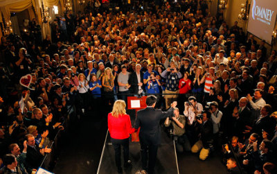 Republican presidential candidate and former Massachusetts Governor Mitt Romney holds hands with his wife Ann as he addresses supporters at his Iowa Caucus night rally in Des Moines, Iowa, January 3, 2012.