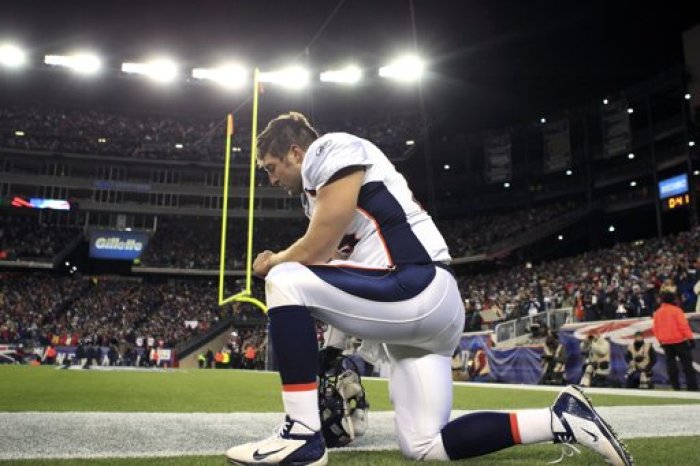 Denver Broncos quarterback Tim Tebow prays before the NFL AFC Divisional playoff football game against the New England Patriots in Foxborough, Massachusetts, January 14, 2012.