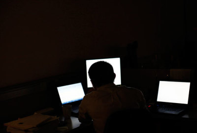 A man sits in front of computer monitors at an office, September 21, 2011.