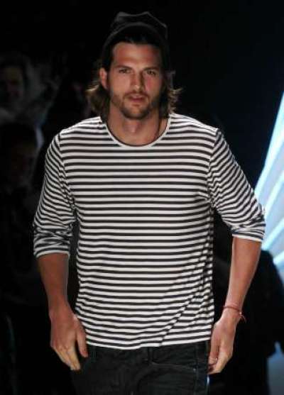 U.S. actor Ashton Kutcher presents a creation from Colcci's Summer 2012 collection during Sao Paulo Fashion week