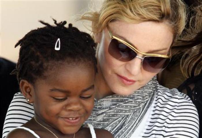 Madonna sits with her adopted Malawian daughter Mercy James during a brick laying ceremony at the cite of her Raising Malawi Girls Academy in April 2010.
