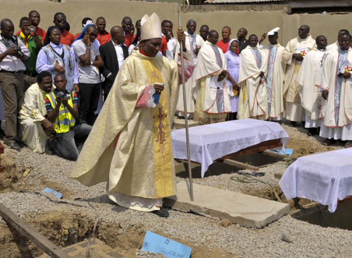 Clergymen gather around the coffins of the victims of the Christmas Day bombing at St Theresa Catholic Church Madalla, during a mass funeral for the victims, outside Nigeria's capital Abuja, February 1, 2012. Islamist sect Boko Haram claimed responsibility for the bombing of St. Theresa Catholic Church in Madalla, on the outskirts of Abuja, which killed 37 people and wounded 57.