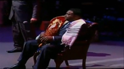 Bishop Eddie Long after being proclaimed a 'king' is seen sitting on a 'throne' while holding a Torah scroll during a Jan. 29, 2012, service at New Birth Missionary Baptist Church.