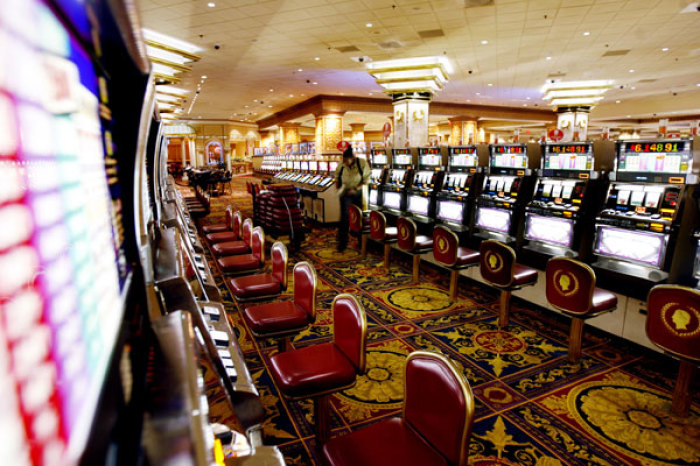 An employee works on slot machine seats along an empty casino floor at Caesars in Atlantic City, New Jersey July 5, 2006.