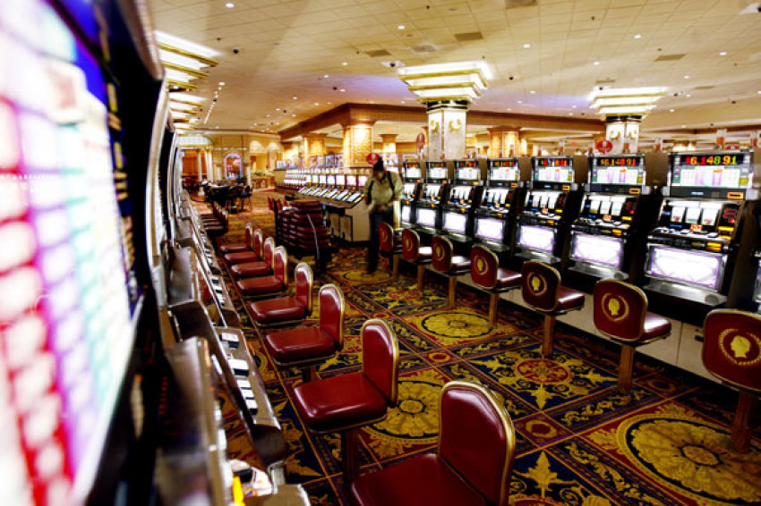 An employee works on slot machine seats along an empty casino floor at Caesars in Atlantic City, New Jersey July 5, 2006.