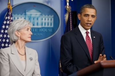 President Barack Obama, with Health and Human Services Secretary Kathleen Sebelius behind him, announces a new health care policy that requires a woman's insurance company to offer contraceptive care free of charge if the woman's religious employer objects to providing contraceptive services as part of its health plan coverage. The announcement was made in the James S. Brady Press Briefing Room of the White House, Jan. 12, 2012.