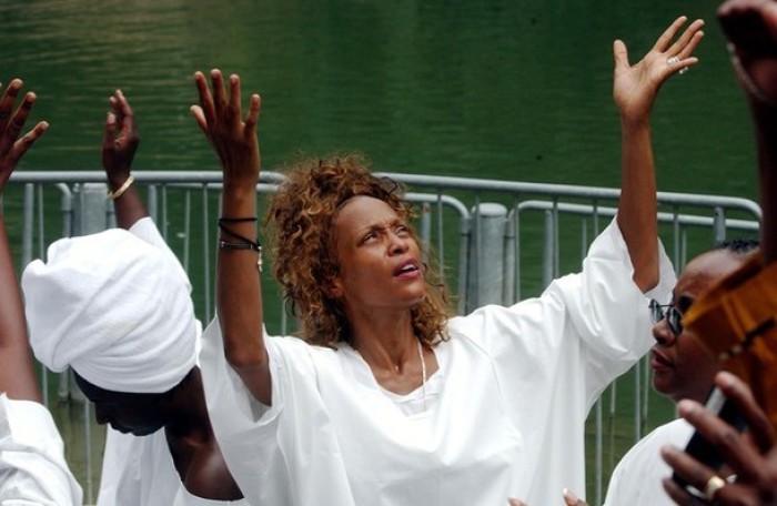 American pop diva Whitney Houston emerges from the waters of the River Jordan near the Sea of Galilee during a Holy Land pilgrimage, in this file photo taken May 29, 2003.