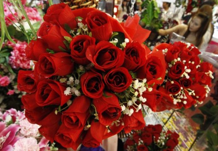 A woman looks at roses for Valentine's Day at a flower shop in Bangkok February 14, 2012.