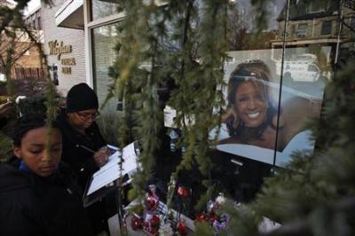 People write messages at the entrance of Whigham Funeral Home, which is handling the funeral service of pop singer Whitney Houston, in Newark, N.J.,Feb. 17, 2012.