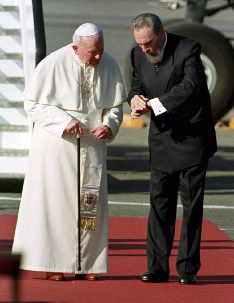 Cuba's leader Fidel Castro (R) stops to read his watch during Pope John Paul II's arrival ceremony at Jose Marti Airport in this Jan. 21, 1998 file photo.