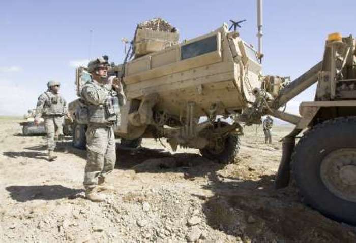 Soldiers of the Army National Guard 162 Engineer Company attached with 2nd Combat Engineer Battalion of U.S. Marine Corps stay next to a Mine Resistant Ambush Protected (MRAP) armored vehicle in Afghanistan, March 6, 2010.