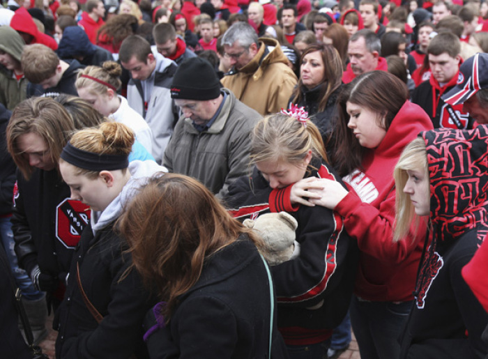 Students and parents gather outside a memorial remembering the victims of the Chardon High school shootings before returning to school for the first time since the shootings in Chardon, Ohio March 1, 2012. Three students were killed and two others wounded by suspect TJ Lane in Monday's shooting rampage at the Ohio high school.