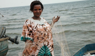 A woman in Uganda who has been assisted by microfinance programs affiliated with World Vision that have enabled her to become one of the few successful women in the fishing business in her country.