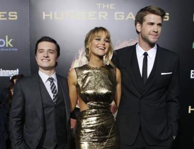 Cast members Liam Hemsworth (R), Jennifer Lawrence (C) and Josh Hutcherson pose at the premiere of 'The Hunger Games' at Nokia Theatre in Los Angeles, California March 12, 2012.