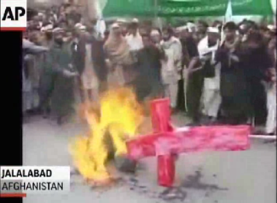 A crowd of Afghan students is seen (in an Associated Press video) burning a cross during a protest on March 13, 2012, following a massacre of 16 civilians, allegedly conducted by a U.S. soldier.