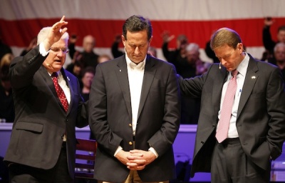 Republican presidential candidate and former U.S. Senator Rick Santorum (C) receives a blessing from Pastor Dennis E. Terry, Sr. (L) after being interviewed by Family Research Council President Tony Perkins (R) at Greenwell Springs Baptist Church in Greenwell Springs, Louisiana March 18, 2012.
