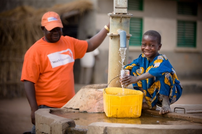 A boy at a community water pump provided by World Vision.