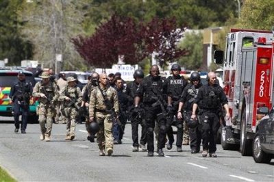 Police officers walk on Edgewater Drive after a shooting at Oikos University in Oakland, California April 2, 2012.