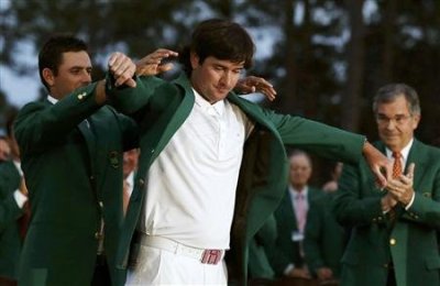 Bubba Watson of the U.S. (C) receives his green jacket from 2011 champion Charl Schwartzel of South Africa as Augusta National Golf Club Chairman William Porter Payne (R) applauds after the 2012 Masters Golf Tournament at the Augusta National Golf Club in Augusta, Georgia, April 8, 2012.