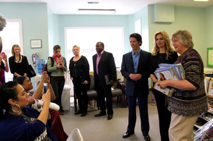 (l-r) Joel Osteen, pastor of Lakewood Church in Houston; his wife, Victoria; and Janet Durig, executive director of the Capitol Hill Pregnancy Center, talk to Joel Osteen Ministries' Generation Hope Project volunteers who are helping to fold pamphlets and renovating rooms in the center on Thursday, April 26, 2012, in Washington, D.C.