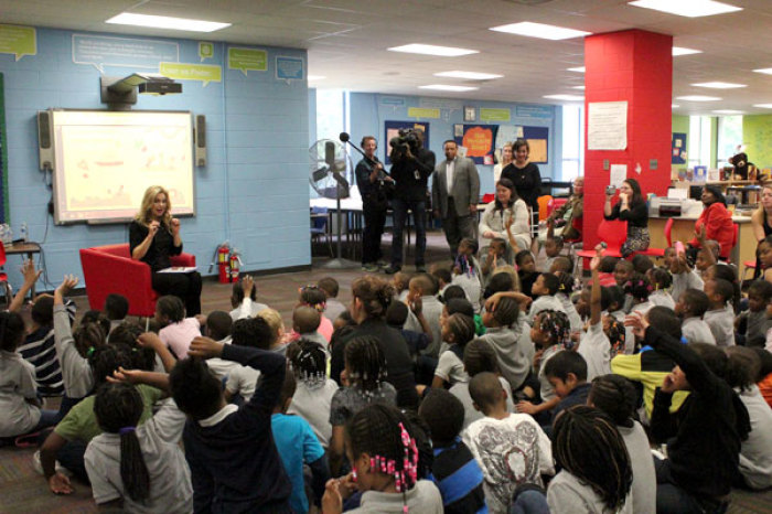 Victoria Osteen reads to children at Amidon-Bowen Elementary School's library as some 75 Generation Hope Project volunteers lay sod, plant flowers, and repaint a rusty fence around the playground of the underserved school on Thursday, April 26, 2012 in Washington, D.C. Generation Hope Project is an outreach of the Joel Osteen Ministries.