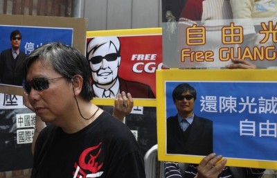 Pro-democracy lawmaker Lee Cheuk-yan stands in front of placards in support of blind Chinese dissident Chen Guangcheng during a protest outside the China Liaison Office in Hong Kong May 4, 2012.