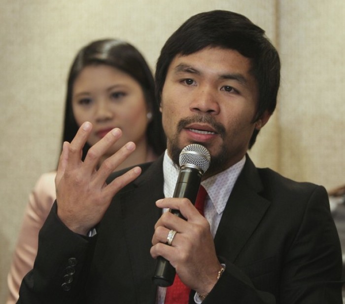 World Boxing Organization welterweight champion and congressman Manny Pacquiao of the Philippines gestures during a press conference in Manila in this March 26, 2012 file photo.
