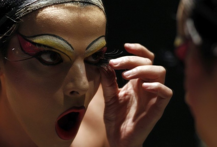 A model adjusts his make-up backstage before a same-sex wedding dress fashion show in Buenos Aires, November 17, 2011.