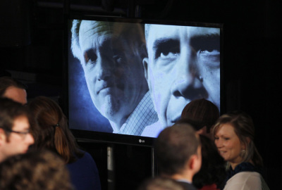 A video screen shows Republican presidential candidate and former Massachussetts Governor Mitt Romney (L) and U.S. President Barack Obama in Columbia, South Carolina January 21, 2012.