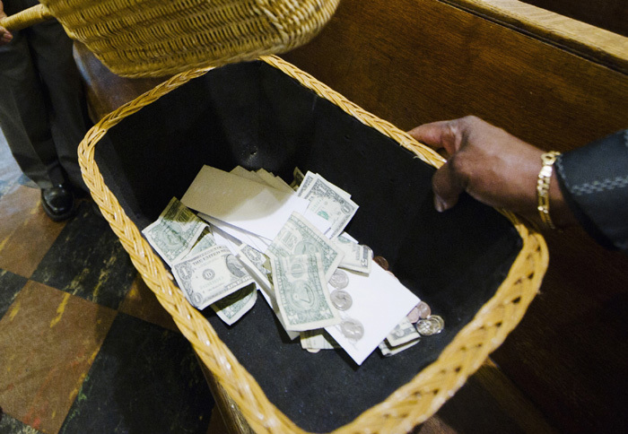 A man collects money from donations in a Detroit church in this file photo.