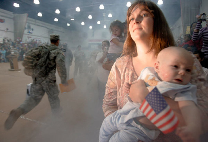 A woman watches as soldiers from the Army's 4th Infantry Division arrive at a homecoming ceremony in Fort Hood, Texas November 28, 2006. The division returned after spending a one year tour in Iraq.