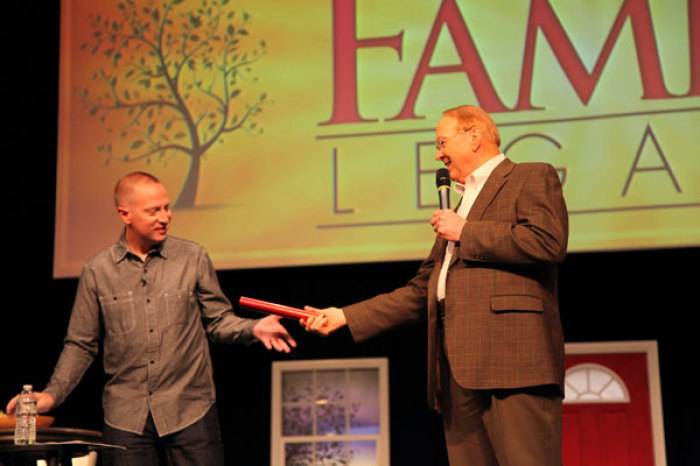 Dr. James Dobson (right) hands a baton to son, Ryan, June 2012.