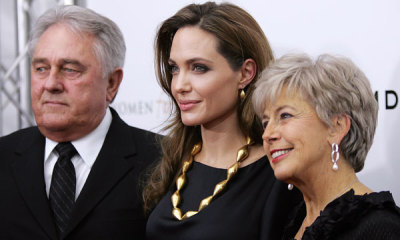 Angelina Jolie (C) poses for photos with her partner Brad Pitt's parents Bill and Jane as they arrive at the screening of her directorial debut 'In the Land of Blood and Honey' in New York December 5, 2011.