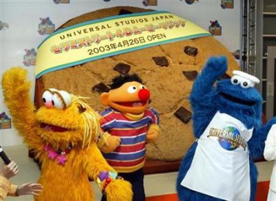 ''Sesame Street'' characters play in front of a large cookie in Tokyo in this file photo from March 13, 2003. Two unique Northern Ireland puppets are to join Elmo, Cookie Monster and Big Bird in a new version of ''Sesame Street'' in Belfast that aims to foster respect between Catholic and Protestant children.