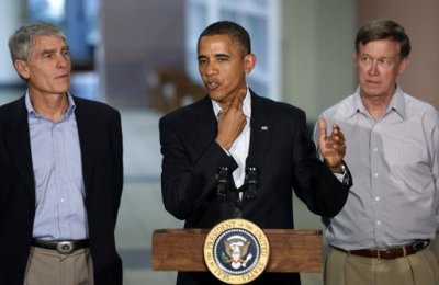 U.S. President Barack Obama (C) demonstrates a story of survival while speaking at the University of Colorado Hospital after he met with families bereaved after a gunman went on a shooting rampage at a movie theater in Aurora, Colorado July 22, 2012. Standing beside Obama are U.S. Senator Mark Udall (L) and Colorado Governor John Hickenlooper (R). Obama headed to Aurora, Colorado, on Sunday to meet families grieving their losses Friday's mass shooting that has stunned the nation and rekindled debate about guns and violence in America.
