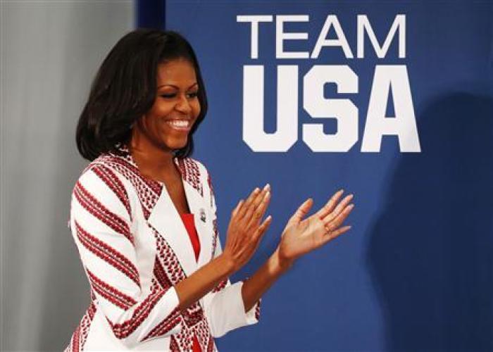 U.S. first lady Michelle Obama claps as she arrives at a Team USA athletes breakfast in London July 27, 2012.