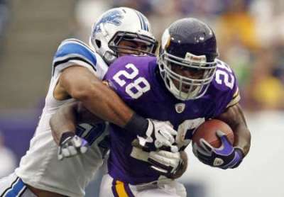 Minnesota Vikings running back Adrian Peterson (front) is tackled by Detroit Lions line backer DeAndre Levy during the fourth quarter of their NFC football game in Minneapolis September 25, 2011. Detroit won the game in overtime.