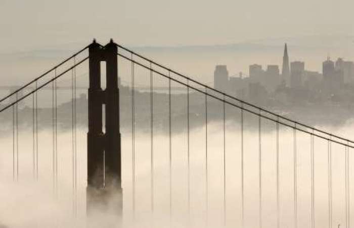 The skyline of San Francisco rises behind the fog-shrouded Golden Gate Bridge from the Marin Headlands in Sausalito, California September 24, 2008.