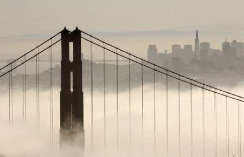 The skyline of San Francisco rises behind the fog-shrouded Golden Gate Bridge from the Marin Headlands in Sausalito, California September 24, 2008.