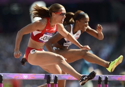 Lolo Jones (L) of the U.S. clears a hurdle with Canada's Phylicia George in their round 1 women's 100m hurdles heat during the London 2012 Olympic Games at the Olympic Stadium Aug. 6, 2012.