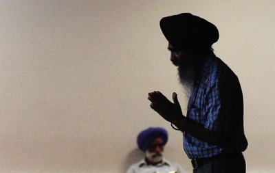 A man holds his hands in prayer as he walks inside the Sikh Cultural Society in the Queens borough of New York August 6, 2012.