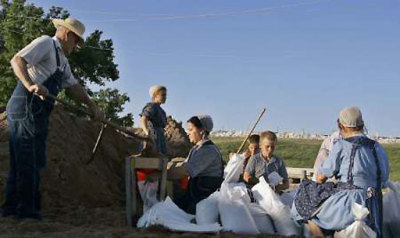 Members of an Amish community fill sandbags to be placed along the levy in Canton, Missouri, in this June 17, 2008 file photo. America's Amish population has nearly doubled and spread out in the past 16 years due to large families, more marriages within the community and longer lifespans, a study showed on August 20, 2008.