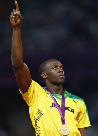 Jamaica's Usain Bolt points upwards as he collects his gold medal on the podium after winning the men's 200m event at the London 2012 Olympic Games at the Olympic Stadium August 9, 2012.