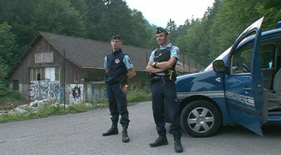 Gendarmes stand by a vehicle on a road near Annecy Lake in Chevaline, southeastern France, in this still image taken from video.