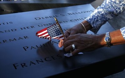 Judy Parisio places an American flag in a plaque of names of the victims of the September 11 attacks at North Pool of the 9/11 Memorial during ceremonies marking the 11th anniversary of the attack on the World Trade Center in New York, September 11, 2012.